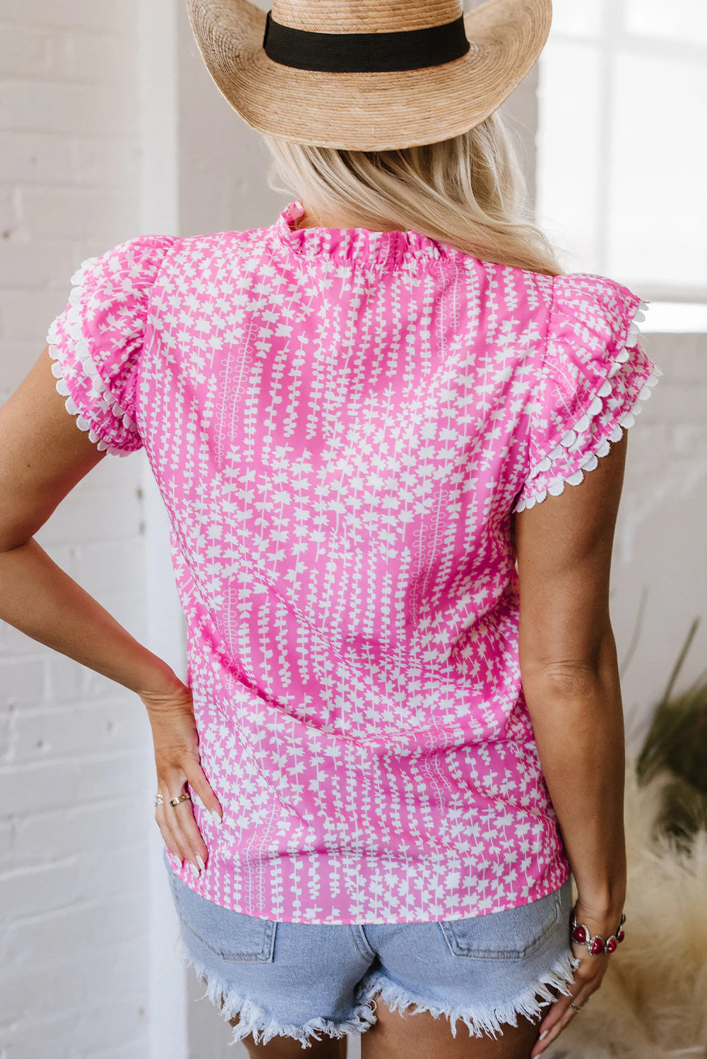 Pink and white print blouse with ric rac trim, flutter sleeves, notch V-neck, and scalloped edges. Sizes available: XS, S, M, L.