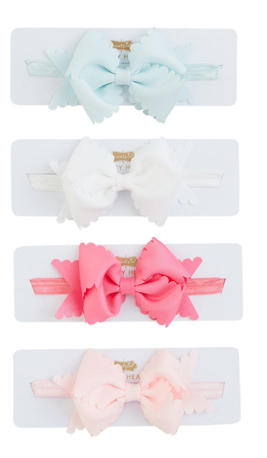Four Scallop Bow Headband Infants in various colors (blue, white, pink, and peach) mounted on cards, each with gold clips, displayed vertically.