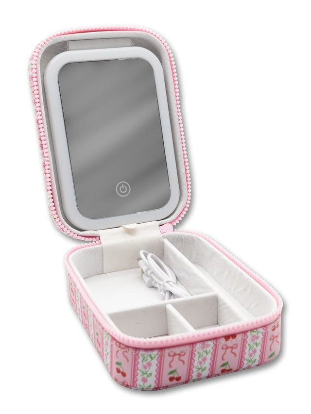 Compact pink zippered jewelry case with built-in mirror, floral bow design, inner compartments, USB cable; sizes: small.