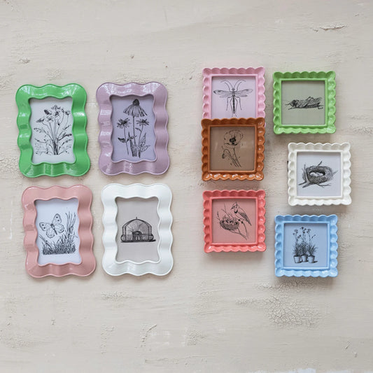 Pastel resin ruffled photo frames with black-and-white nature prints; available in 4x6" and 5x7" sizes. Set of nine.