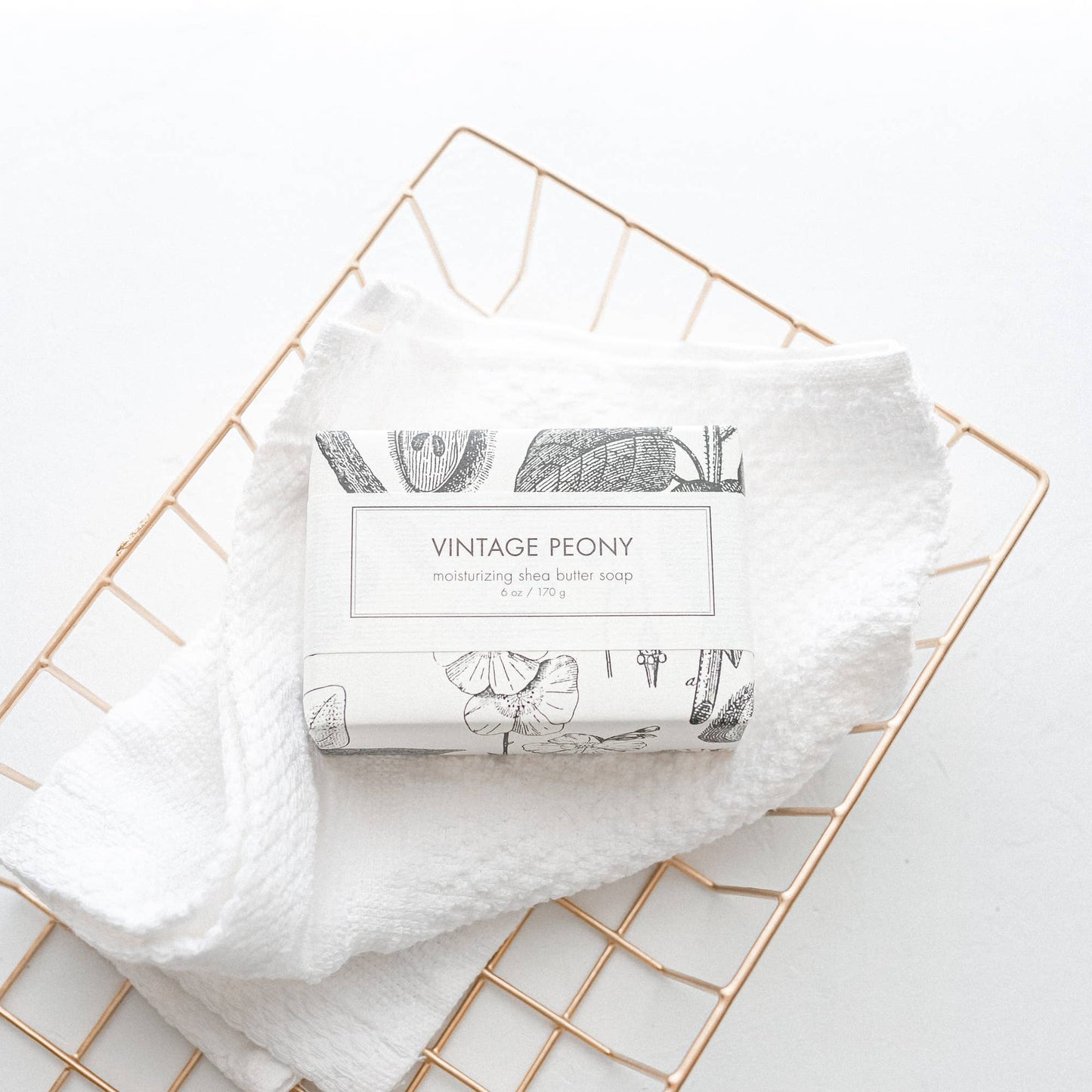 The product is a "Vintage Peony Soap - Bath Bar". It's wrapped in elegant packaging and delivers a luxurious bathing experience. It features a soft, floral fragrance that adds charm to your daily routine. Comes as a single bar.