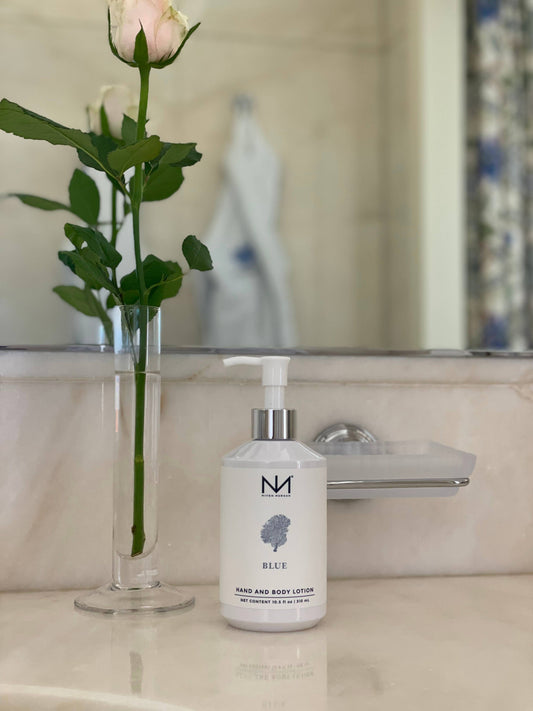 White bottle of Blue Hand and Body Lotion; seaside fragrance, soothes dry skin. Available in 250ml and 500ml sizes.