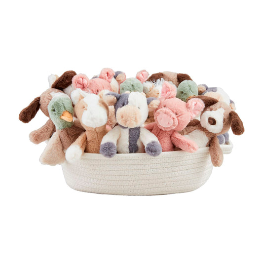 The Farm Plush Rattle Pals set includes a white woven basket with plush pigs, cows, and goats in pastel pink, green, brown, and cream. Sizes available: One size for each plush toy.