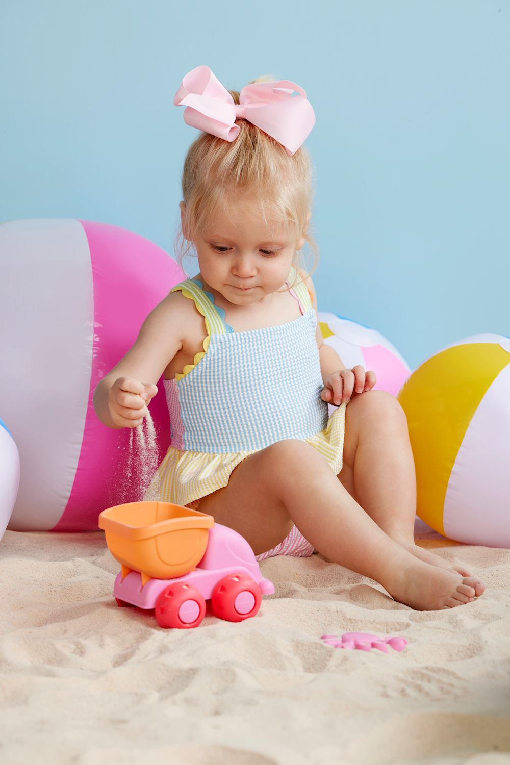 Girls' Seersucker Ric Rac Swimsuit with pink bow. Available sizes: 2T, 3T, 4T, 5T.