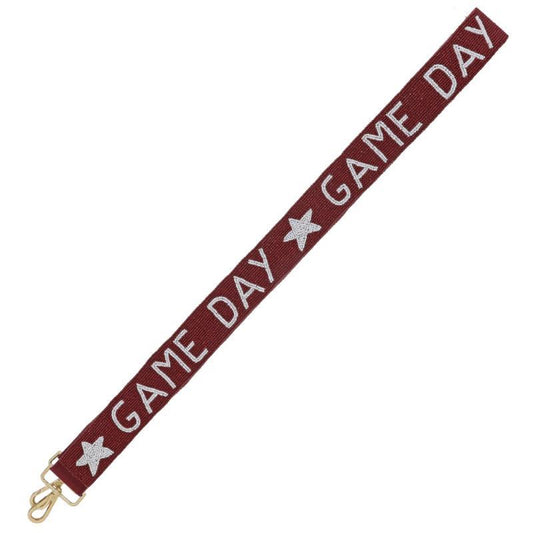 The Game Day Beaded Purse Strap is maroon with white "GAME DAY" lettering and white star graphics, featuring a gold swivel clip. Sizes available: One Size.