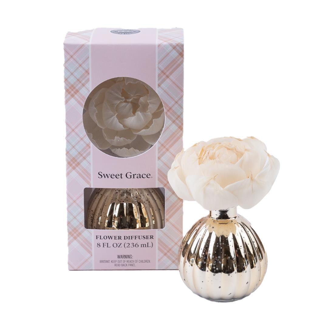 Boxed Sweet Grace Holiday Flower Diffuser with gold ribbed vase, large pale pink flower, pastel plaid packaging. Size not specified.