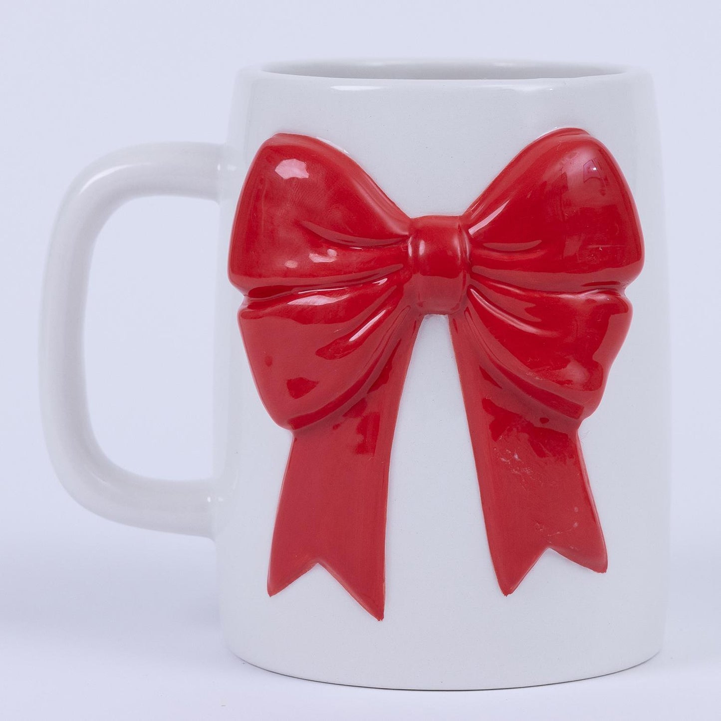 **Product:** The Organic Bow Mug
**Description:** White ceramic mug with a large, raised red bow decoration. Microwave safe.
**Sizes Available:** Standard 12 oz.