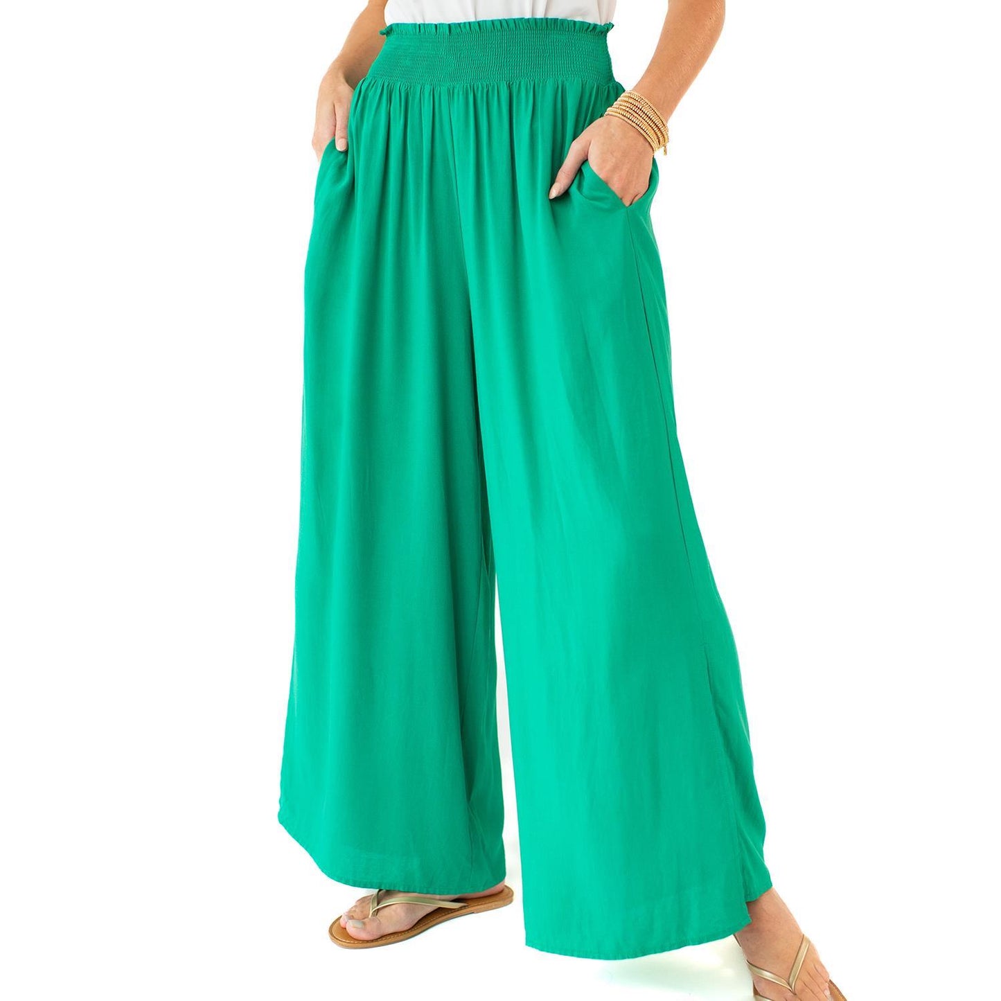 The Krista Pants in bright green feature a smocked waist and wide-leg design. Available sizes: XS, S, M, L.