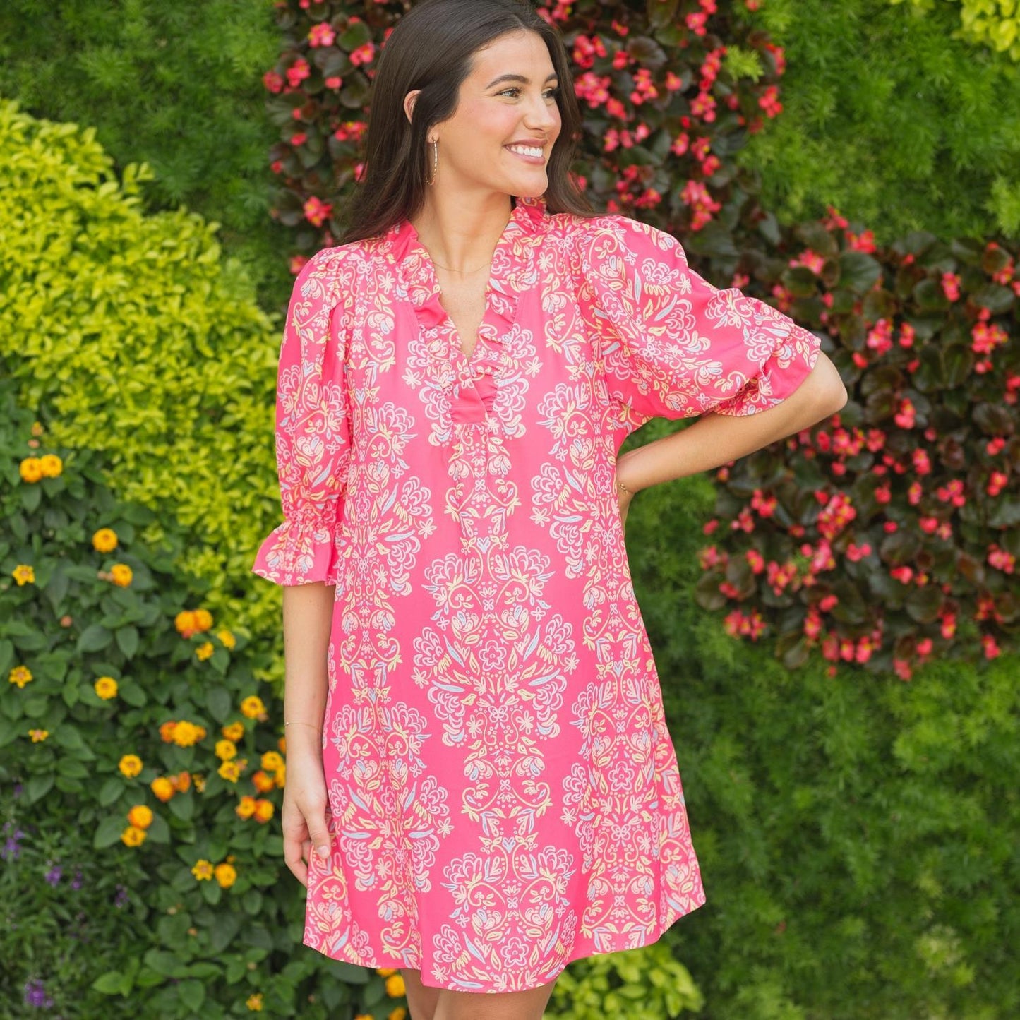 The "Julie Dress" is a bright pink dress with a floral pattern. It is available in sizes small, medium, and large.