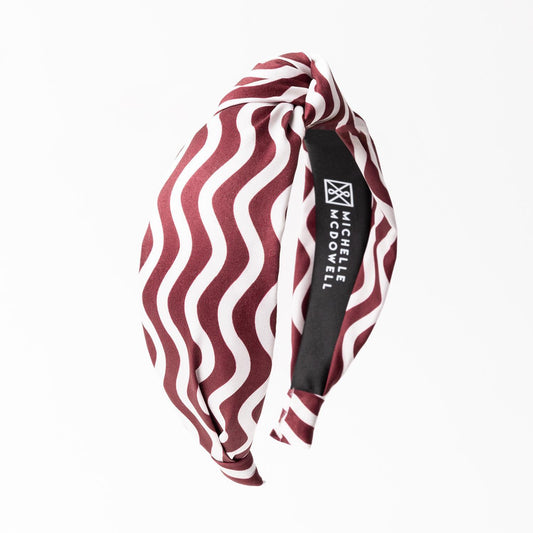 The Luna Touchdown Headband features a maroon and white wavy pattern and a "MICHELE MCDOWELL" label. Available sizes: One size fits all.