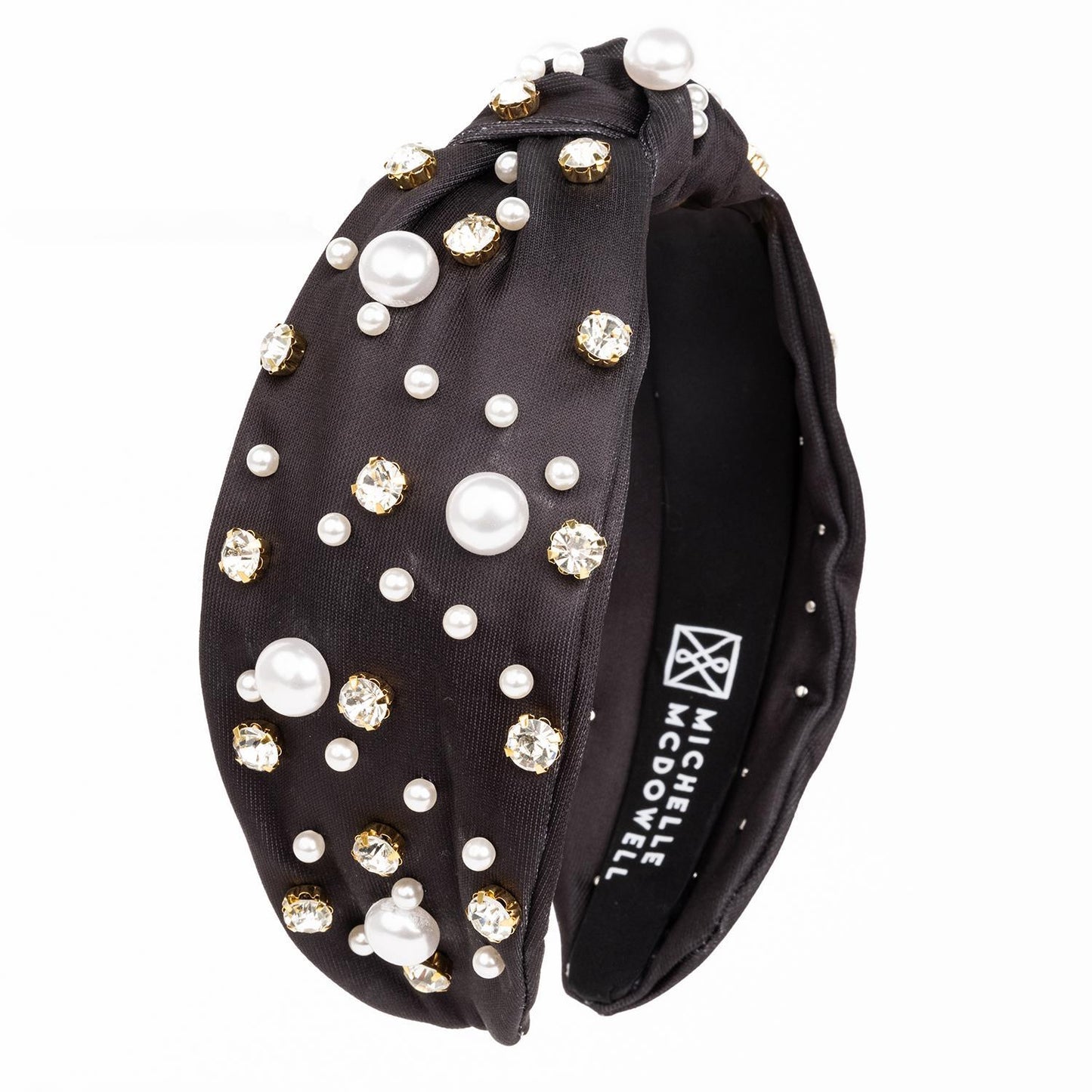 The Charleigh Headband in black features pearls and crystal-like stones with a glossy finish. Available in one size.