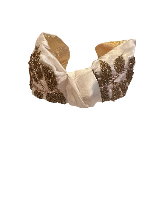 Cream sequin headband with padded satin and gold beaded leaf designs, available in one size.