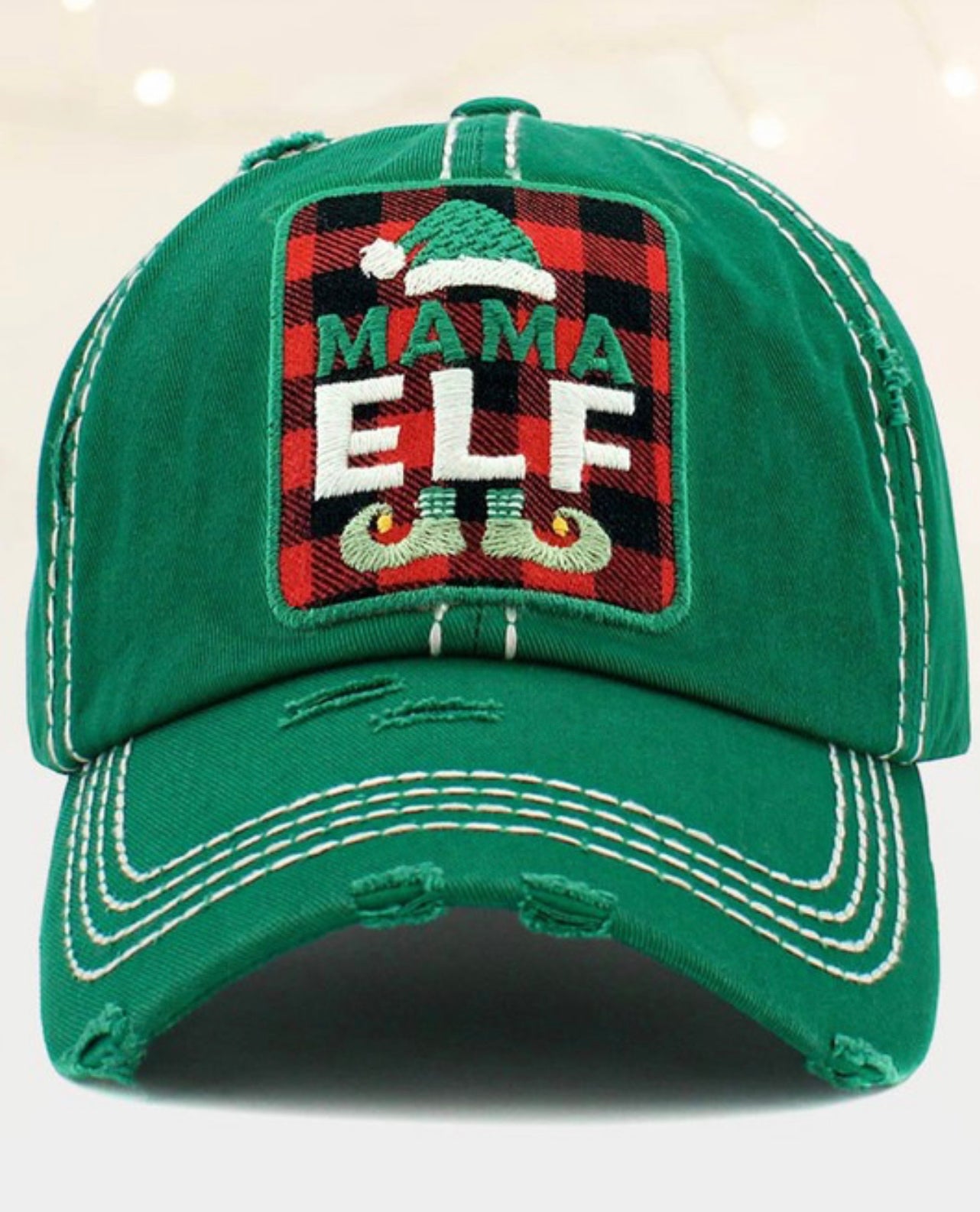 Green baseball cap with white stitching, distressed look, patch with Santa hat, elf shoes, "MAMA ELF" text. Sizes: adjustable.