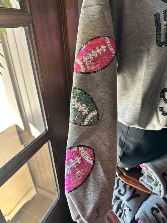 Grey Classy Game Day Sweatshirt with three sequined footballs—pink, green, magenta—on sleeve. Sizes: S-XL.