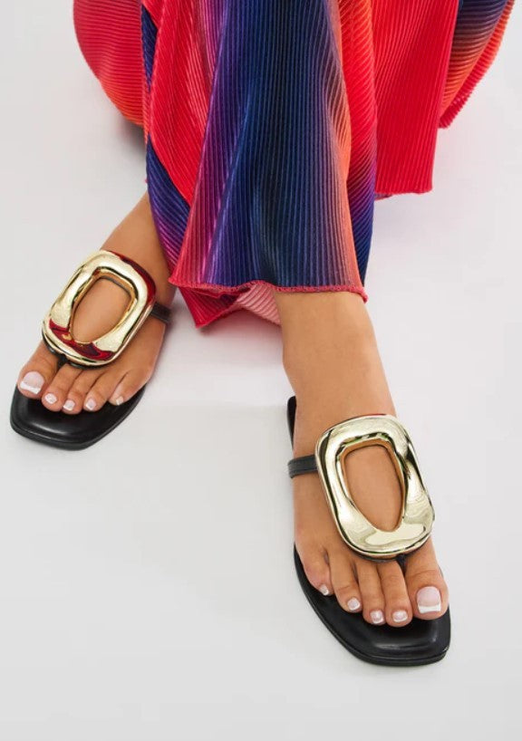 The Bree Sandal: Black women’s sandals with large, shiny gold buckles and a cushioned insole. Available in sizes 5–11.