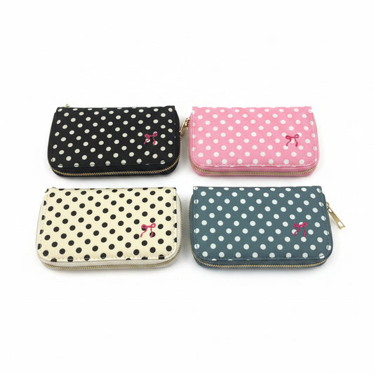 Set of four compact zippered pouches with polka dots in black, pink, cream, and blue, each featuring a small bow. Available in small, medium, large, and extra-large sizes.