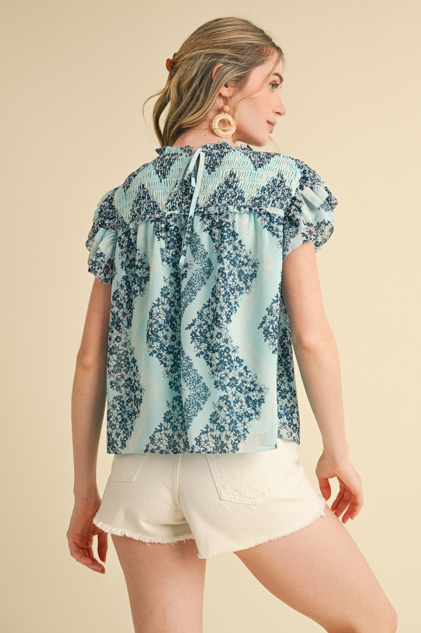 Teal Floral Smocked Yoke Ruffle Trim Top, available in sizes XS-XL. Features ruffle trim and floral pattern.