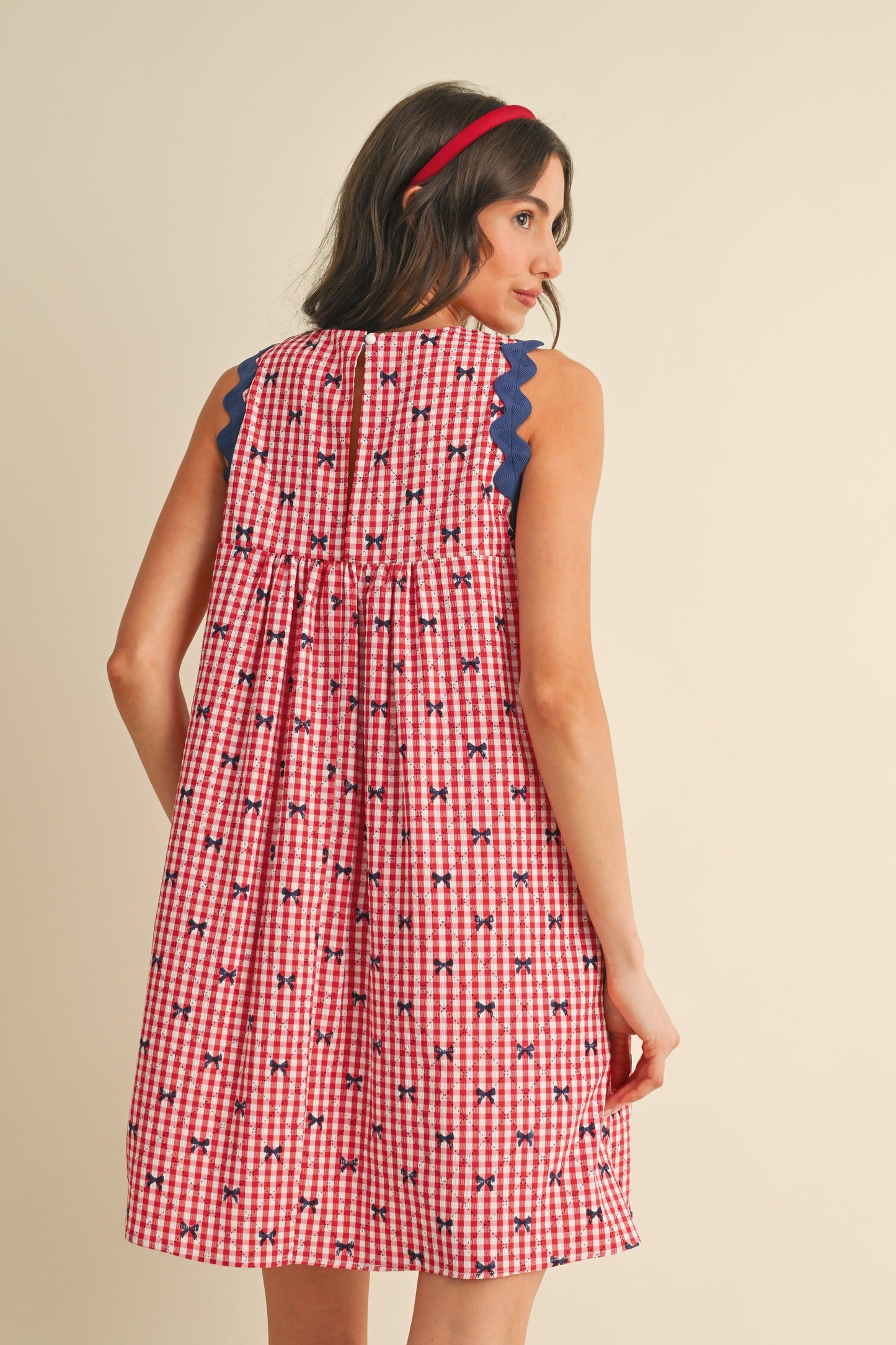 Miss Americana Bow Print Dress: Sleeveless, bow print design, red accent at the collar. Sizes available: XS, S, M, L, XL.