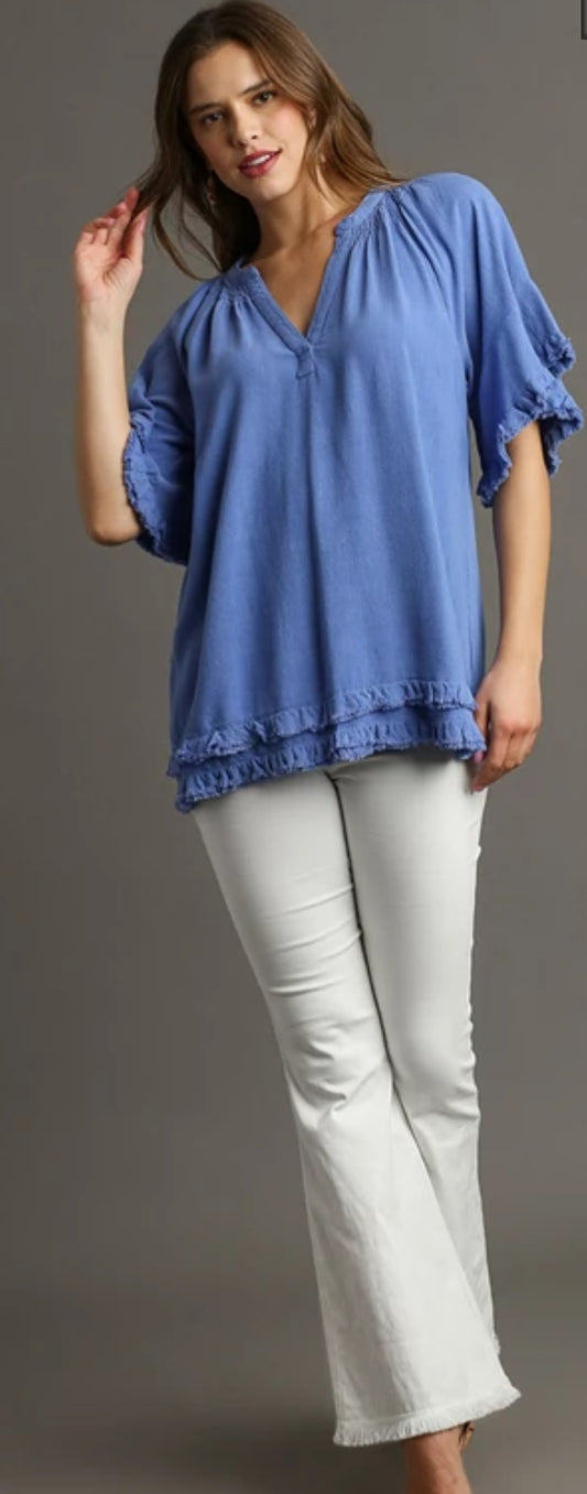This linen shirt is 55% linen and 45% cotton. It’s a V-neck with a ruffle boxy cut top with frayed two tier him at the bottom puff sleeves. It’s not lined. It comes in orchard blue honey, and cream comes and sizes small to large.