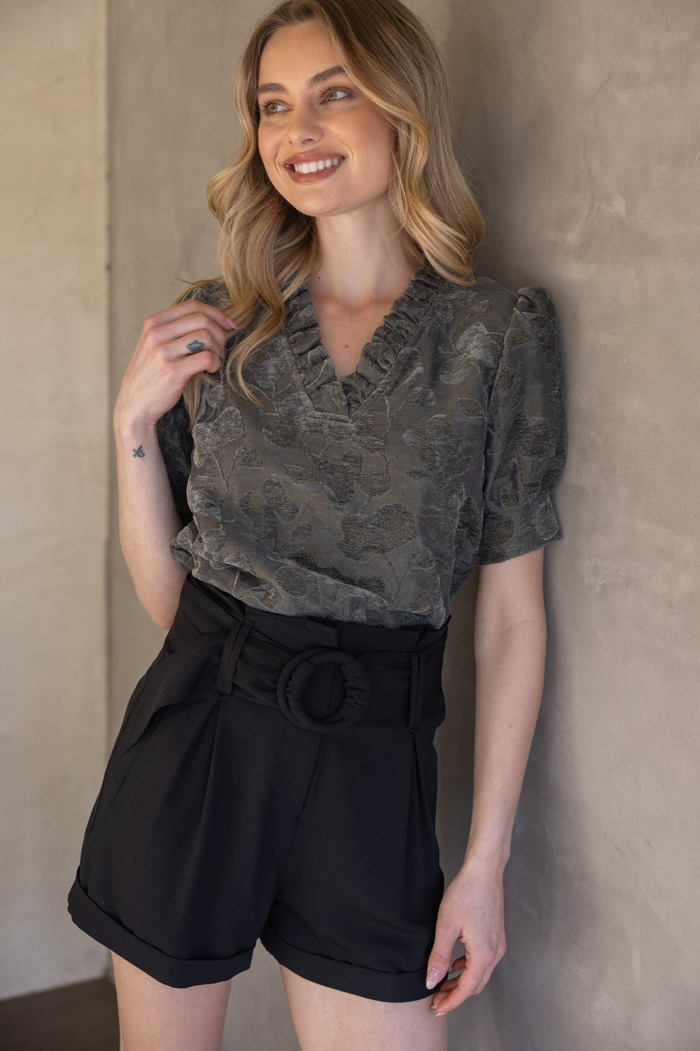 Charcoal Ruffled V-Neck Textured Velvet Top, sizes XS-XL. Features ruffled neckline and plush velvet fabric.