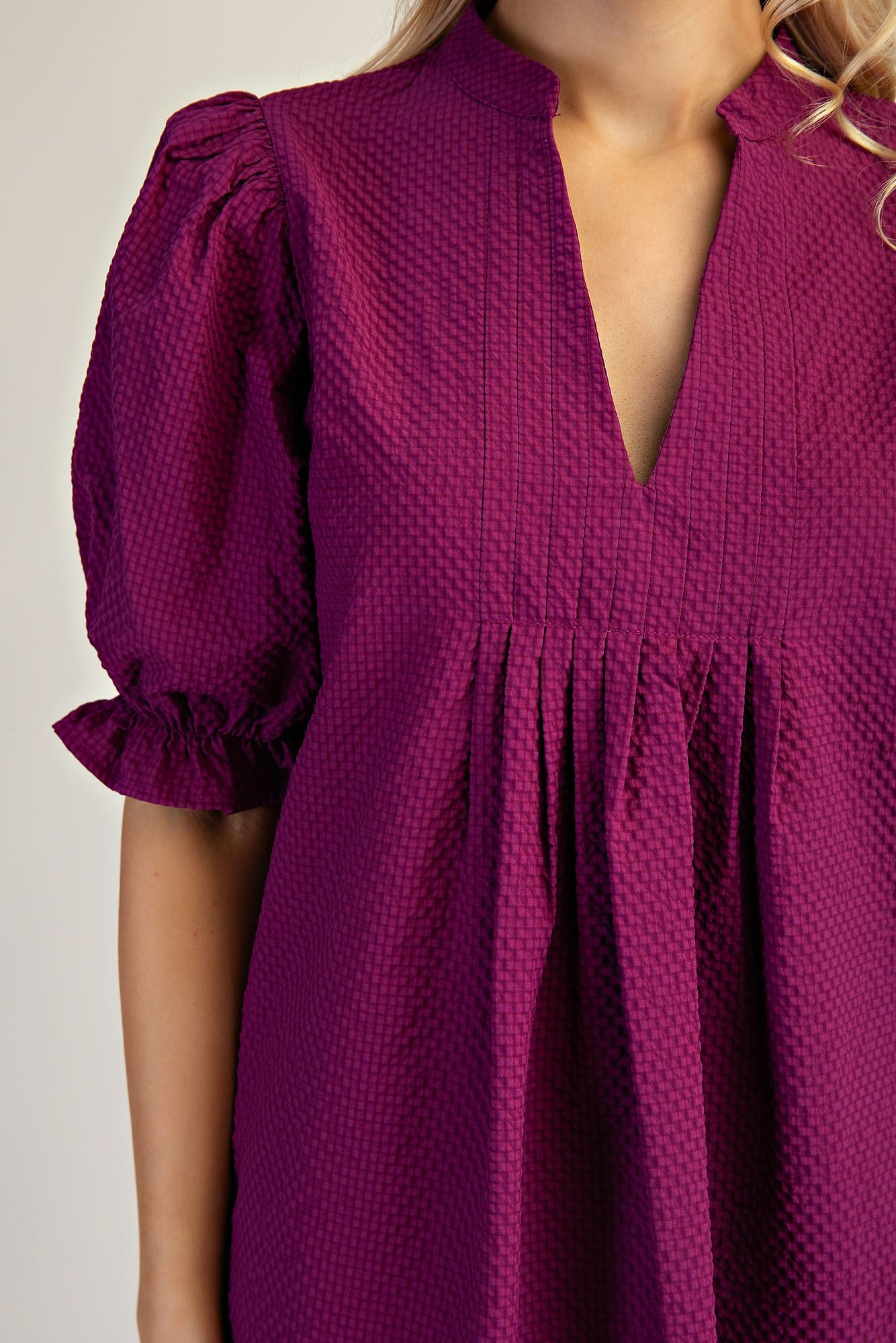 Lyla Puff Sleeve Dress in textured deep purple with short ruffled cuffs and deep V-neckline. Available in sizes XS-XL.