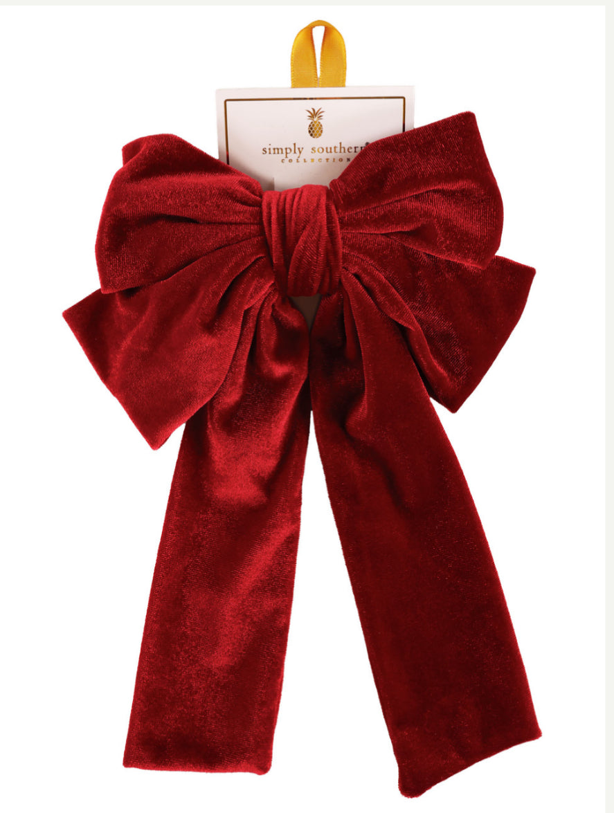 Large deep red velvet bow with long tails, gold hanging loop, on Simply Southern card. Available in one size.