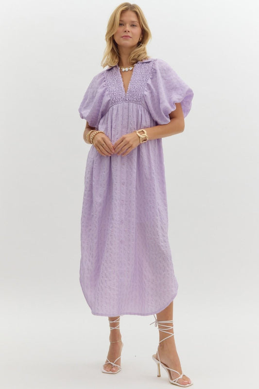 Flowing Lavender Midi Dress with puff sleeves, smocked bodice, ruffle accents. Available in sizes XS-XL.