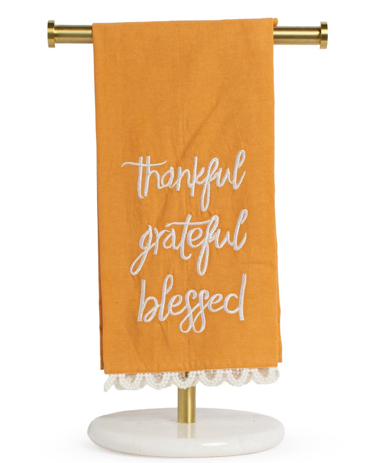 The Thankful Grateful Hand Towel is an orange towel with white embroidered words “thankful, grateful, blessed” and a crocheted lace trim at the bottom edge. Sizes available: standard hand towel.