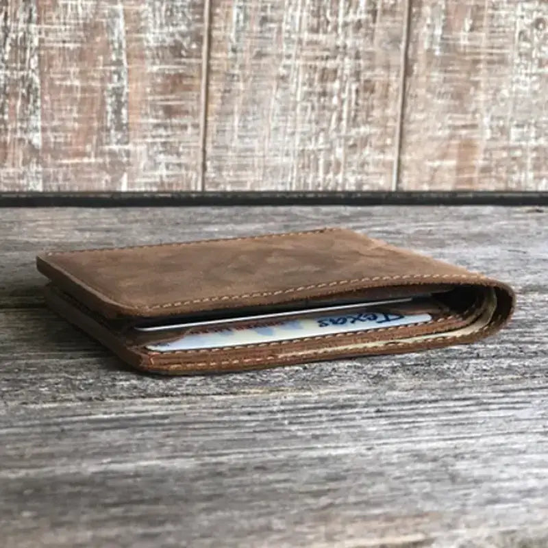 Rustic brown genuine leather bifold wallet, handmade for men, shown closed with a card partly visible; available in all sizes.
