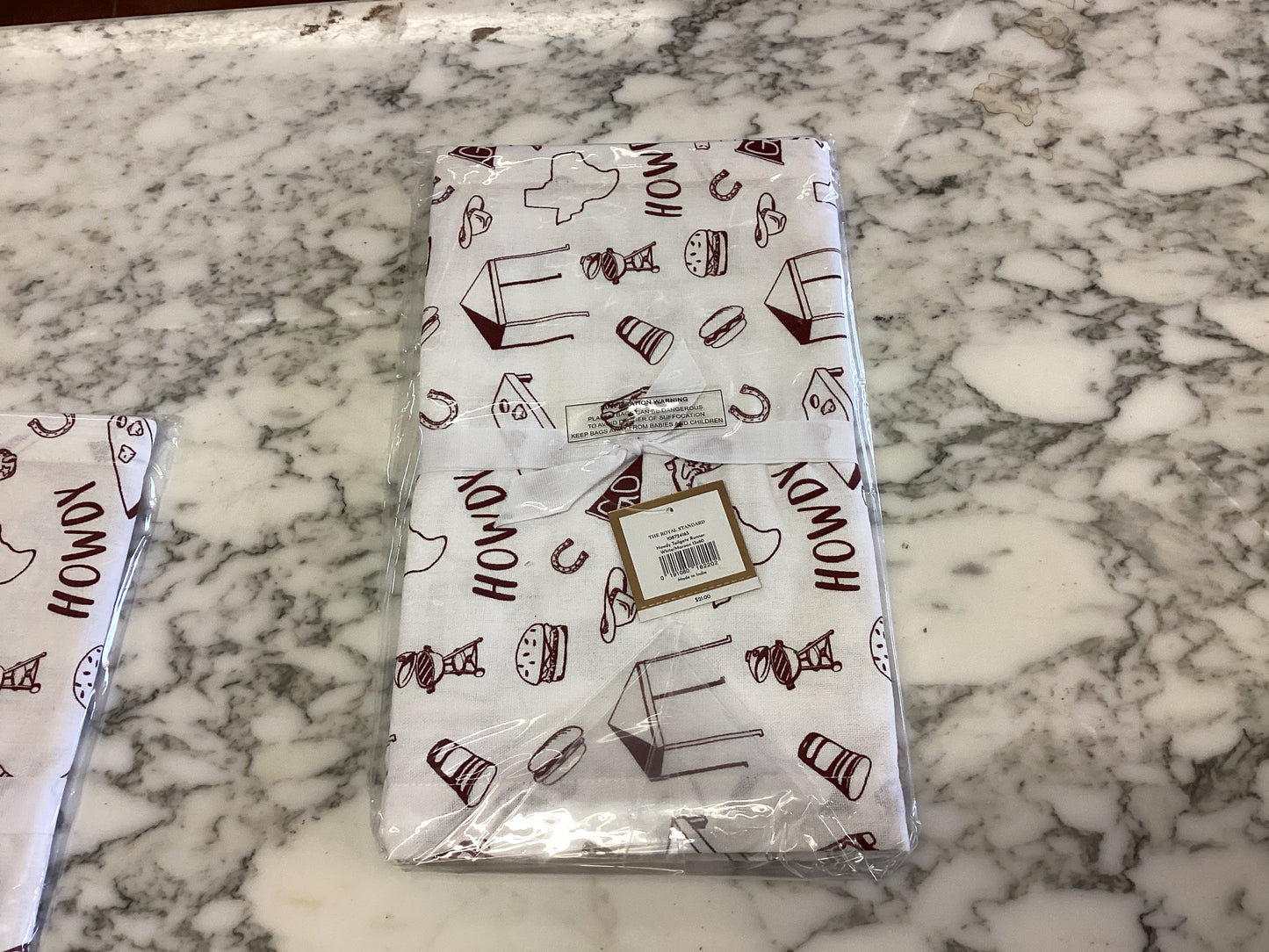 White and maroon "HOWDY" tailgate table runner, Western style, folded in clear plastic. Sizes available: 72", 90".