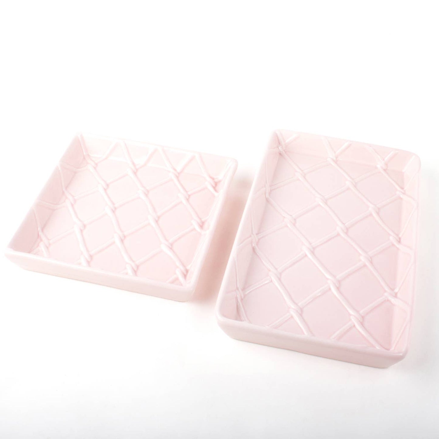 Two pink guest towel trays with raised crisscross diamond pattern; available in standard and large sizes.
