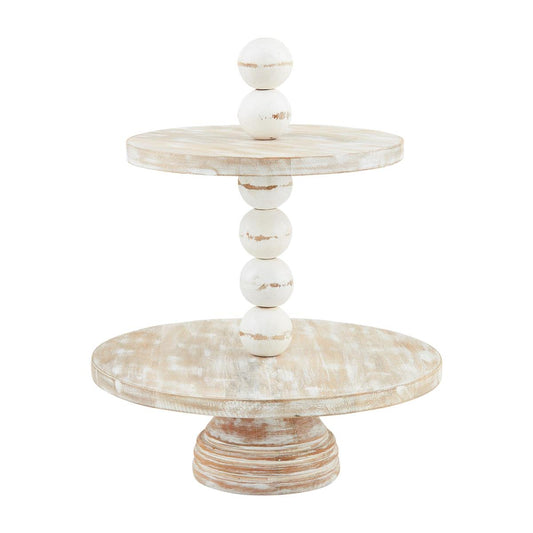 The Chunky Beaded Tiered Server features two rustic, round trays made of distressed white mango wood, connected by a column of wooden spheres. Ideal for serving or decorative use. Available sizes: 18" diameter and 2-tier height.