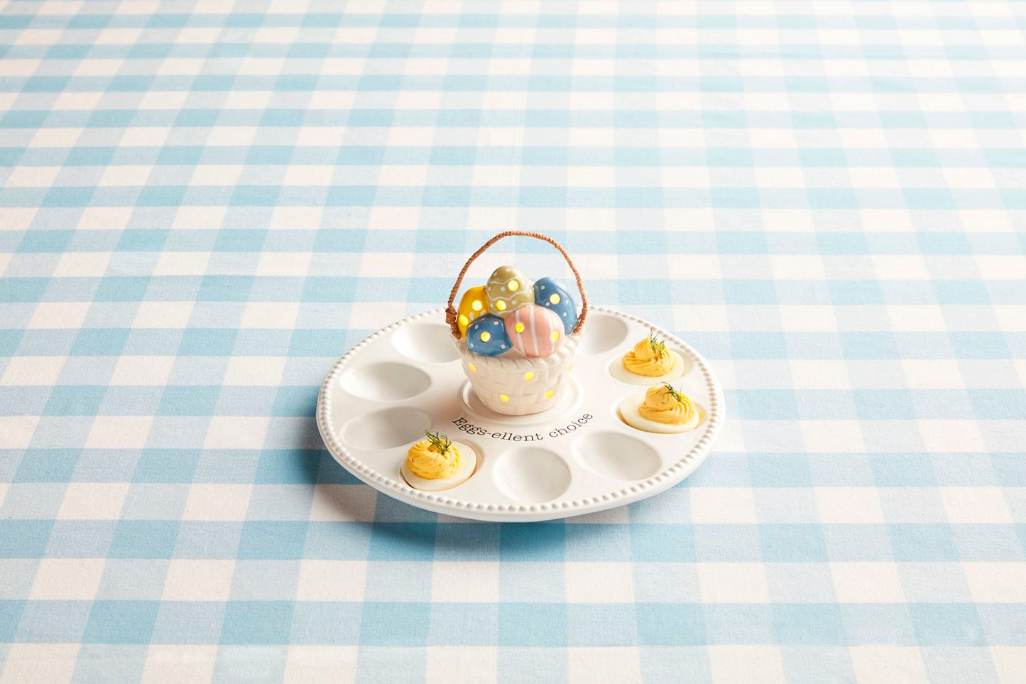 The Deviled Egg Tray Light-Up Holder features a ceramic design with space for four deviled eggs, complemented by a colorful egg holder shaped like an ornate basket. Available in one size.