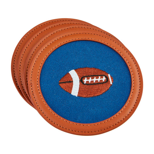 Set of four coasters with blue fabric center, embroidered football design, faux leather trim, and brown stitching. Sizes available: One size.