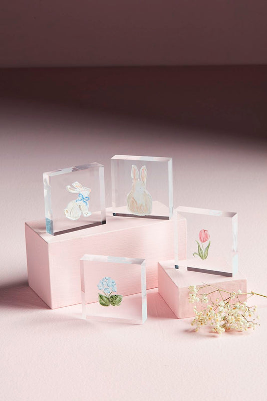 Spring Acrylic Block Set: Five hand-painted acrylic blocks featuring two rabbits, a pink tulip, and a blue flower on pastel pink platforms, adorned with white flowers. Available sizes: 4x4 inches each.