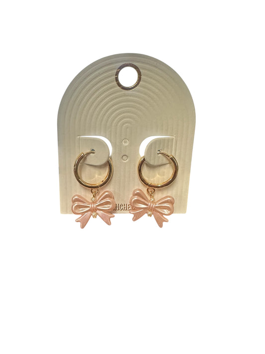 Gold thin huggie hoop earrings with hammered hoops and light pink bow pendants. Available sizes: small, medium, large.