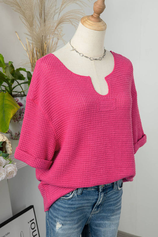 This woman textured knit split neck short sleeve top is in hot pink with a rounded V-neck cuffed short sleeves comes in sizes small medium, large and extra large