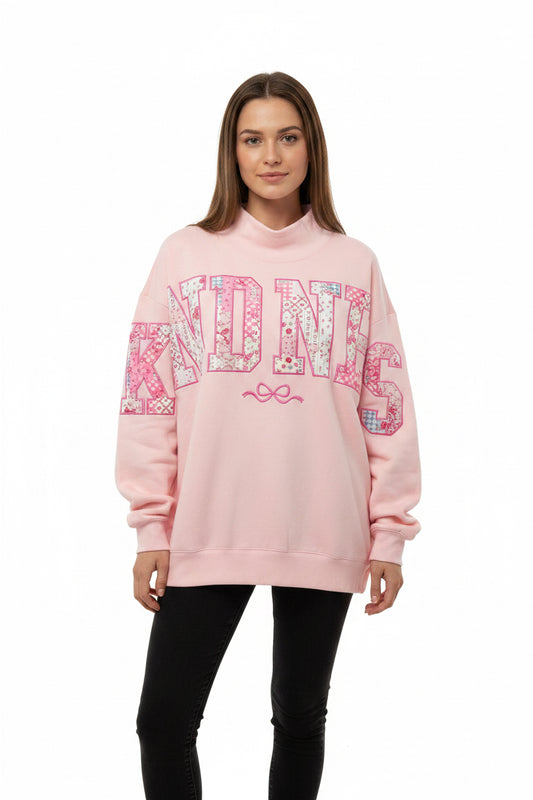 Kindness Mock Neck Sweatshirt with "KINDNESS" in bold pink and white letters. Available in sizes XS-XXL.