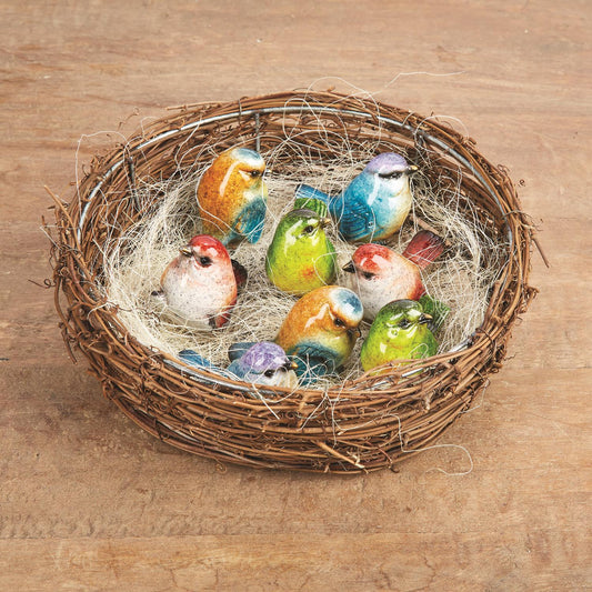 Set of eight hand-painted resin birds in a round twig nest with straw. Sizes: 3"x3".