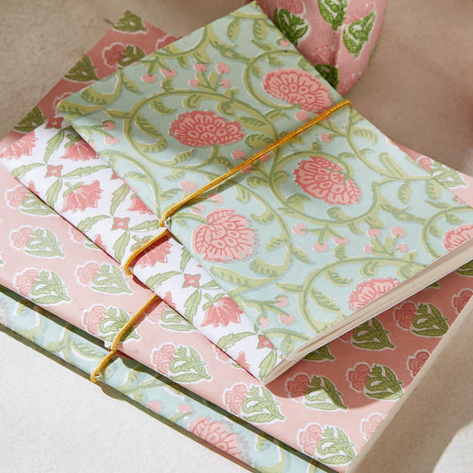 Are these floral block print soft cover notebooks are closed by a gold elastic strand their variables are blue pink and white with various floral designs