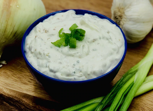 Blue bowl of creamy Roasted Garlic Dip Mix topped with green onions. Available in 4oz and 8oz sizes.