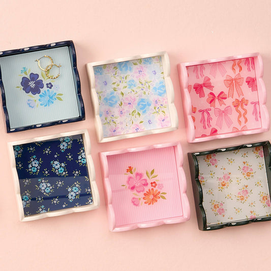 Six square Scallop Trinket Trays with scalloped edges and floral bow patterns in pastel, navy on light pink. Sizes: various.