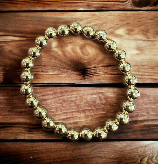 Gold stainless steel beaded bracelet in a circular arrangement. Available sizes: S, M, L.
