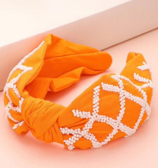 The Game Day Seed Beaded Check Knot Headband with orange and white beads in crisscross pattern. Available in one size.