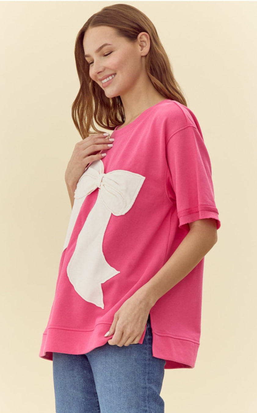 Pink Ribbon Shirt: Bright pink oversized U-neck T-shirt with a large white bow design on the front. Available in sizes S, M, L, XL.