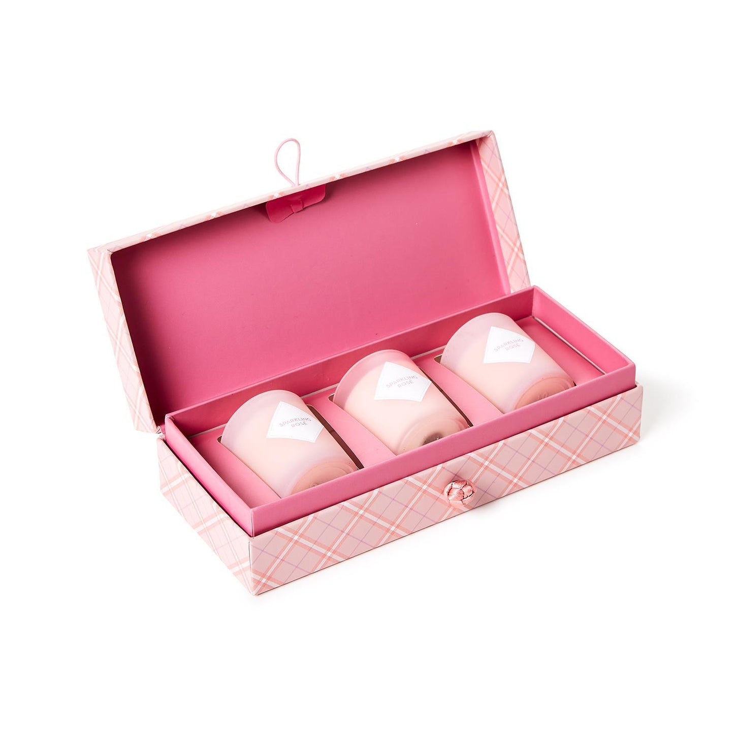 Pink checkered box with button clasp holding three sparkling rosé candles, each wrapped in white paper. Sizes: small, medium, large.