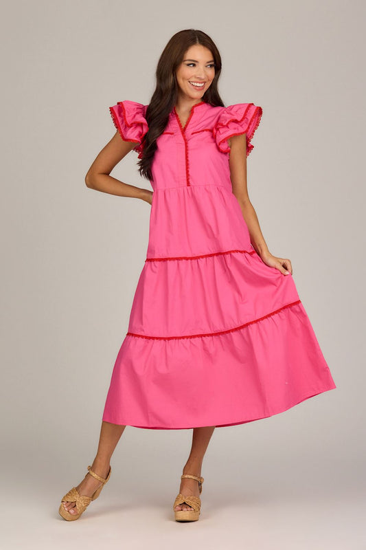 The Pia Ric Rac Midi Dress features pink cotton poplin, ruffled sleeves, and red trim. Available in sizes XS to XL.
