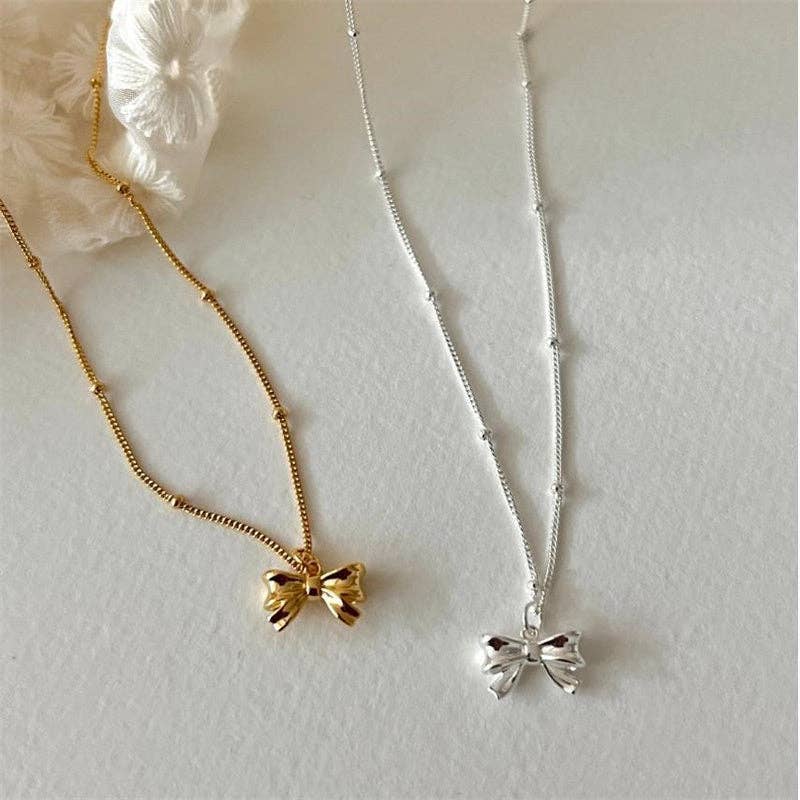 Dainty 925 sterling silver necklace with a small bowknot charm. Available in 16", 18", and 20" chain lengths.