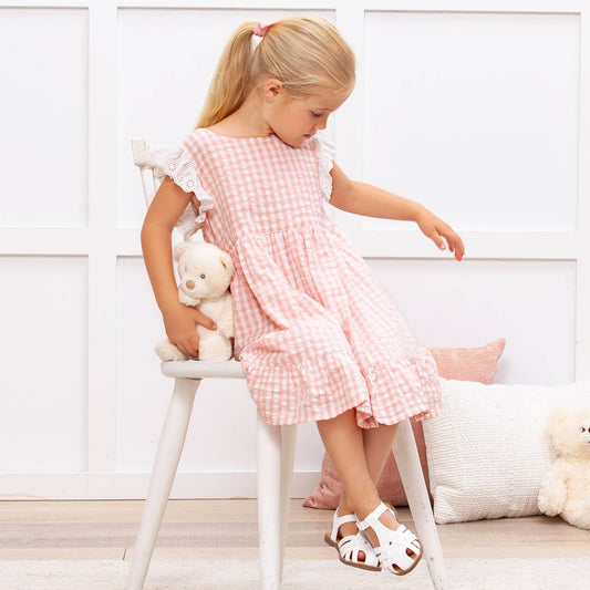 Pink gingham eyelet flutter sleeve cotton dress. Sizes available: 2T-6T. Dress only shown, no accessories included.
