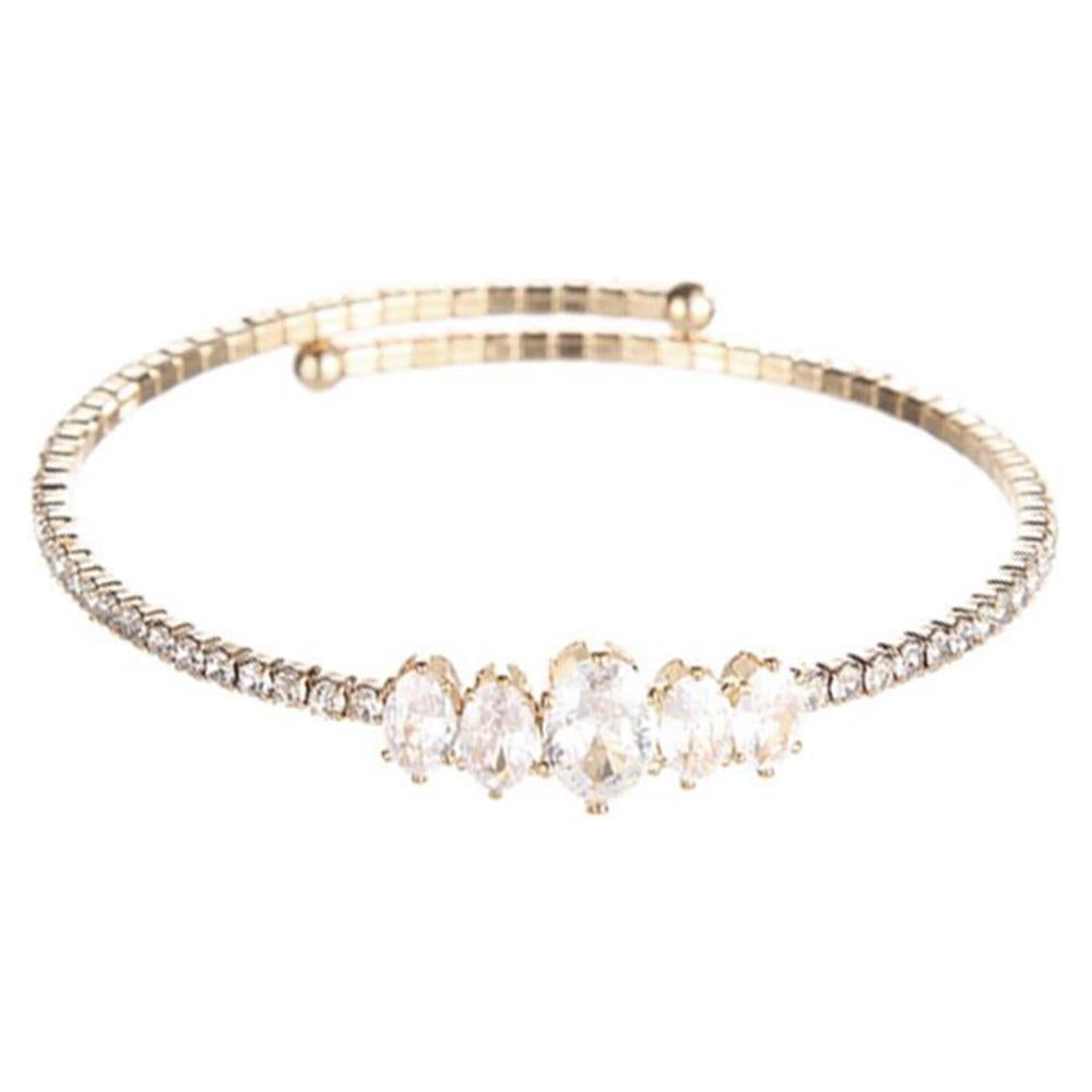 Slim gold bangle with five large oval clear gemstones, baguette and round crystal accents. Available in S, M, L.